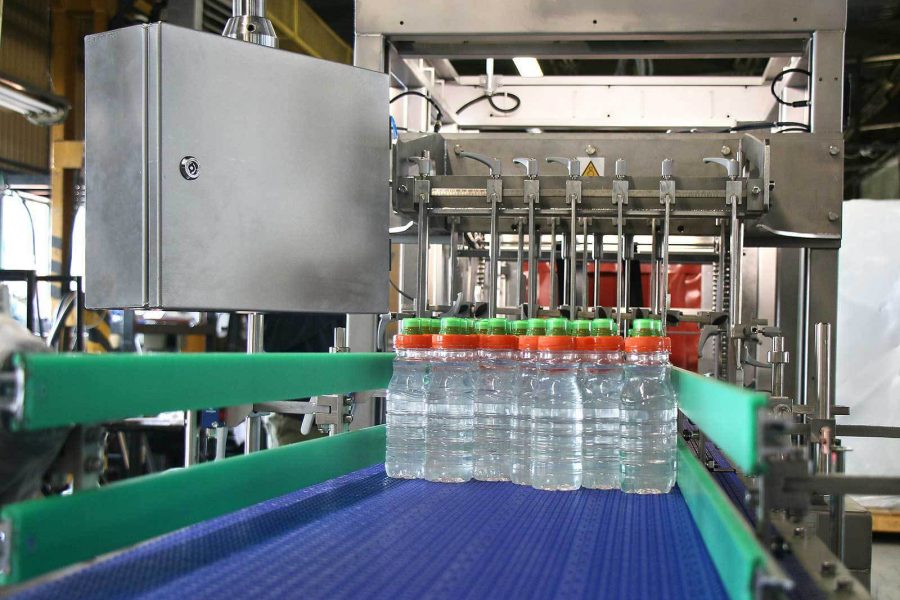 Bottles are fed into the shrink wrapper machine, ready to be bundled.