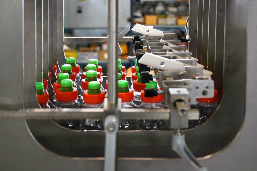 Shrink wrapper machine with bottles inside, ready for packaging.